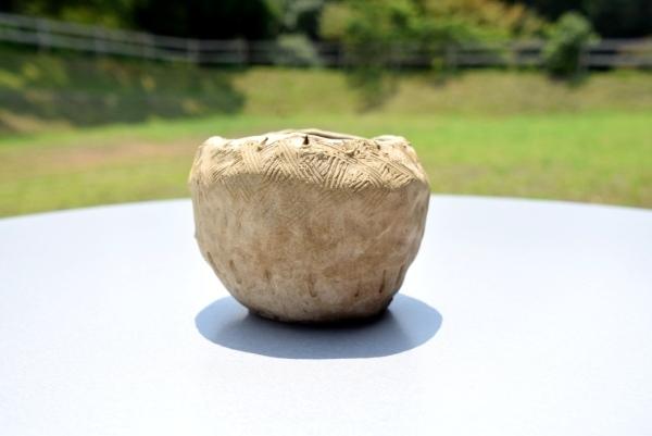 リンゴの様な形をしていて、器の外側に線の文様が付けられている土器完成品5の写真