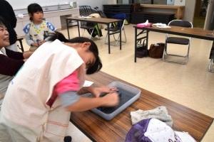 参加した女の子が、長机の上で石庖丁を一生懸命削っている写真