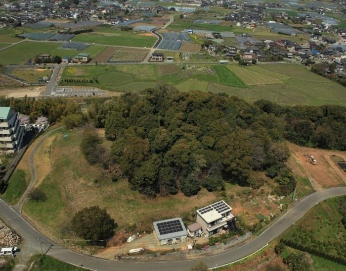 周辺には田畑が広がり住宅が点在し、小高い丘の上には樹木が覆っている善蔵塚古墳を上空から撮影した写真