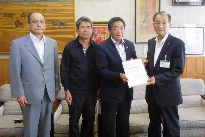 三田村市長に義援金を手渡している八女ライオンズクラブの代表者3名の写真