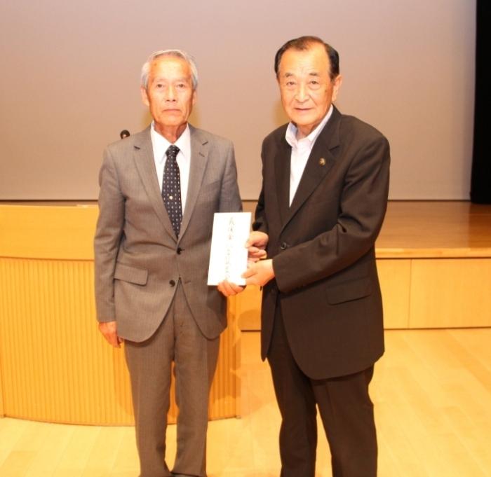 八女市行政区長会の梶原秀喜会長が市長に義援金を手渡している写真