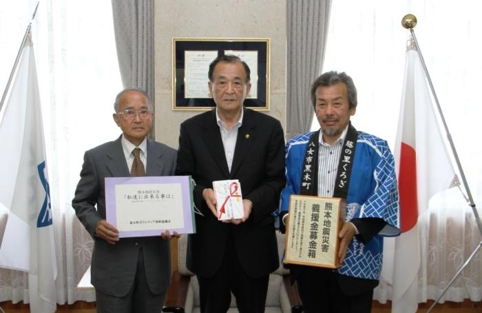 八女黒木大藤まつりで募金活動をした実行委員の方が募金箱を手渡している写真