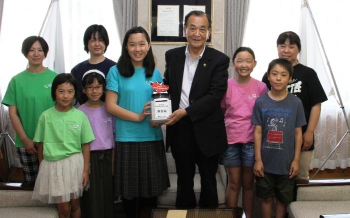 劇団リトルウイングの代表の子供達が市長に義援金を手渡している写真