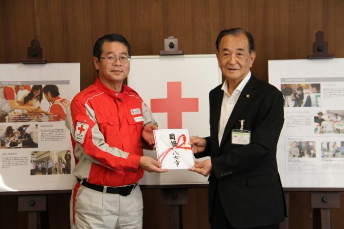 三田村市長が日本赤十字社の担当者に義援金を手渡している写真