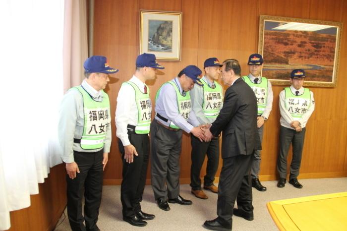 派遣する職員の手を握り激励する三田村市長