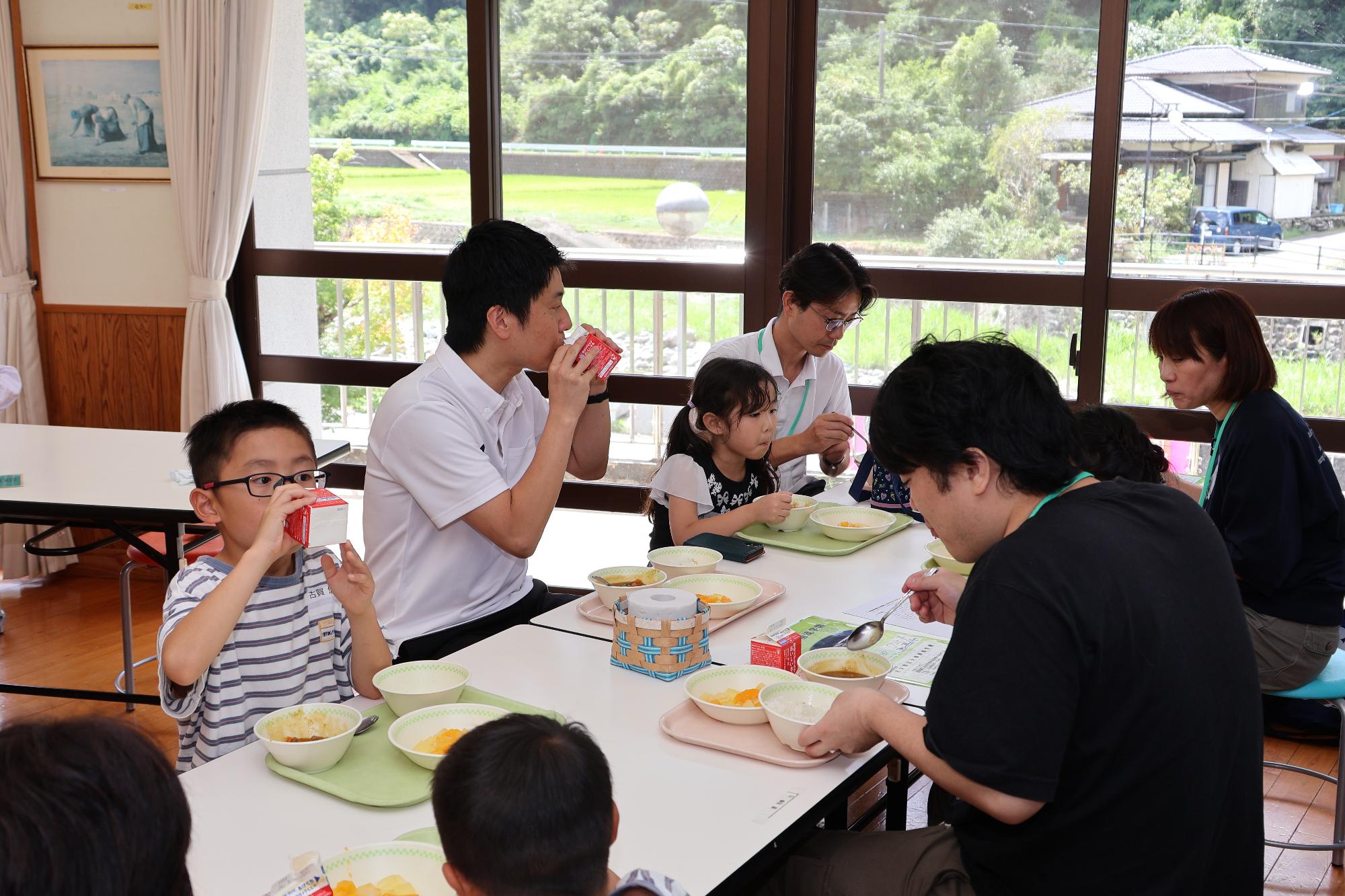 給食を試食する参加者と簑原市長