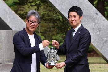 平和の火が灯されたランプを手渡す様子