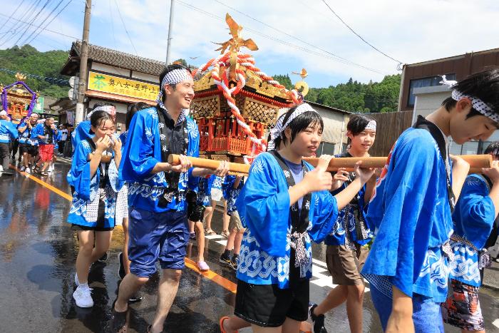 神輿を担いで練り歩くずぶ濡れの市長の様子