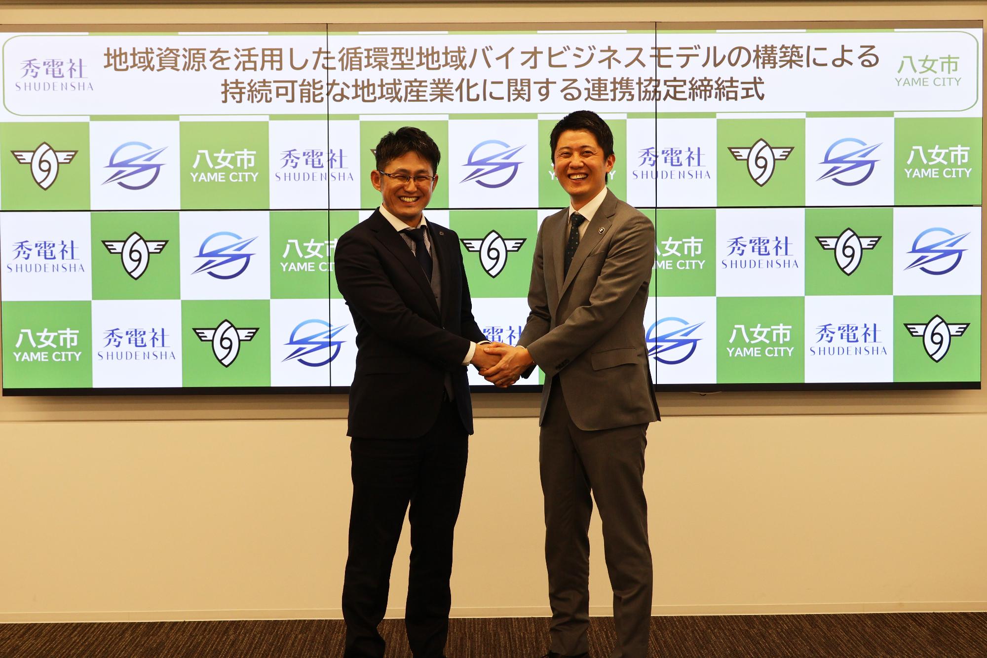 簑原市長と秀嶋社長の握手