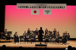 筑南中学校吹奏楽部が舞台上で演奏している写真