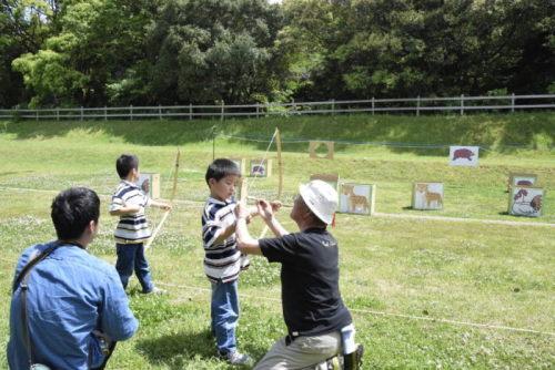 子供たちが弓矢体験をしている写真