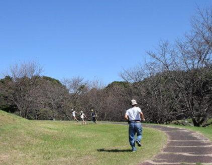 晴天の下、古墳にてかけっこ大会が行われている写真