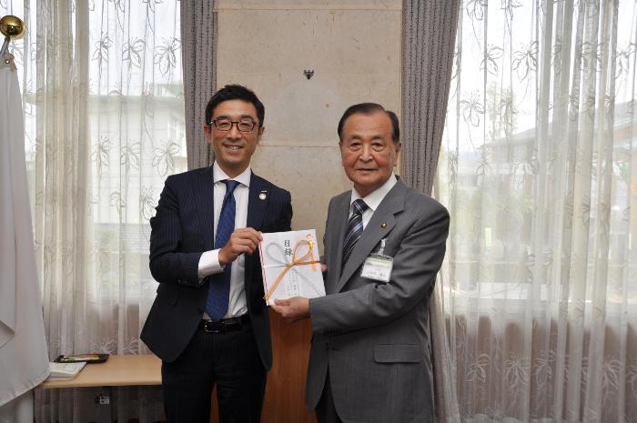 NTTドコモ九州支社長から義援金目録を受け取る三田村市長
