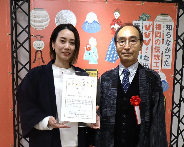 賞状を持つ受賞者と贈呈者